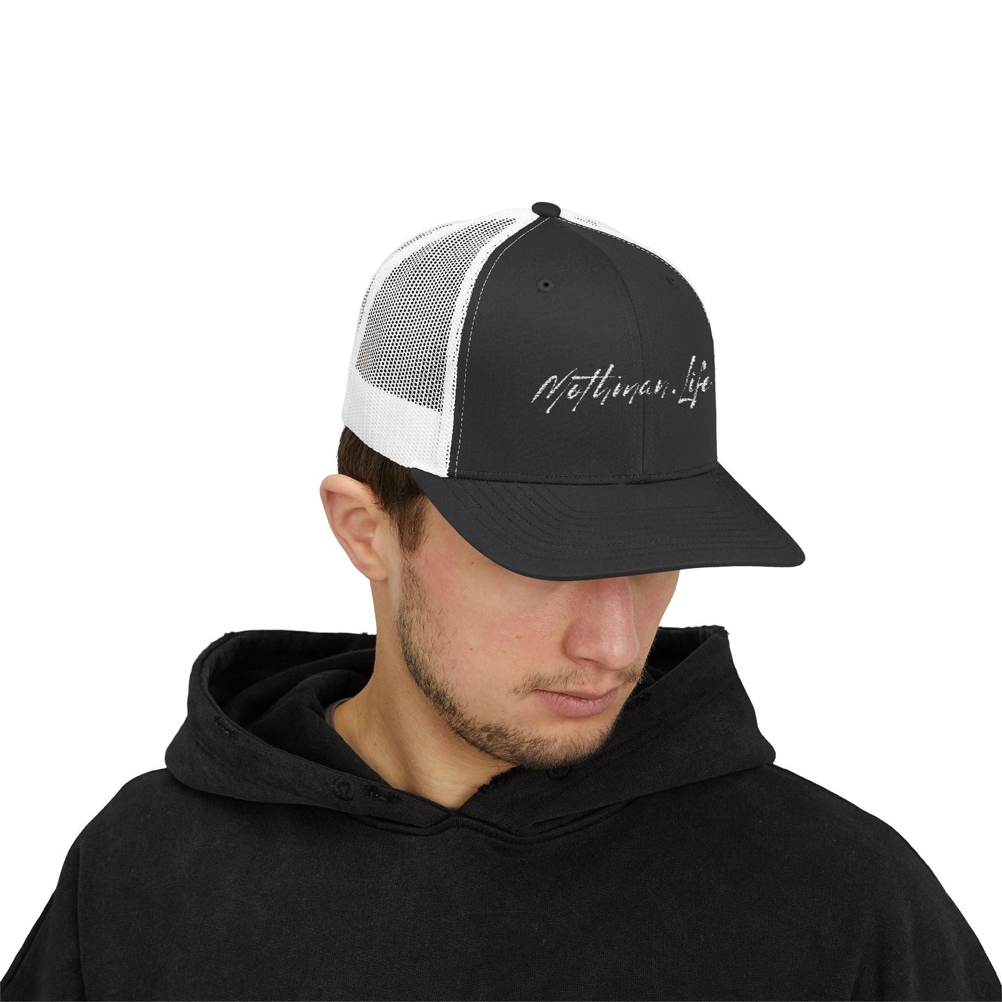 Man wearing a black and white "Mothman Life" trucker hat and black hoodie.
