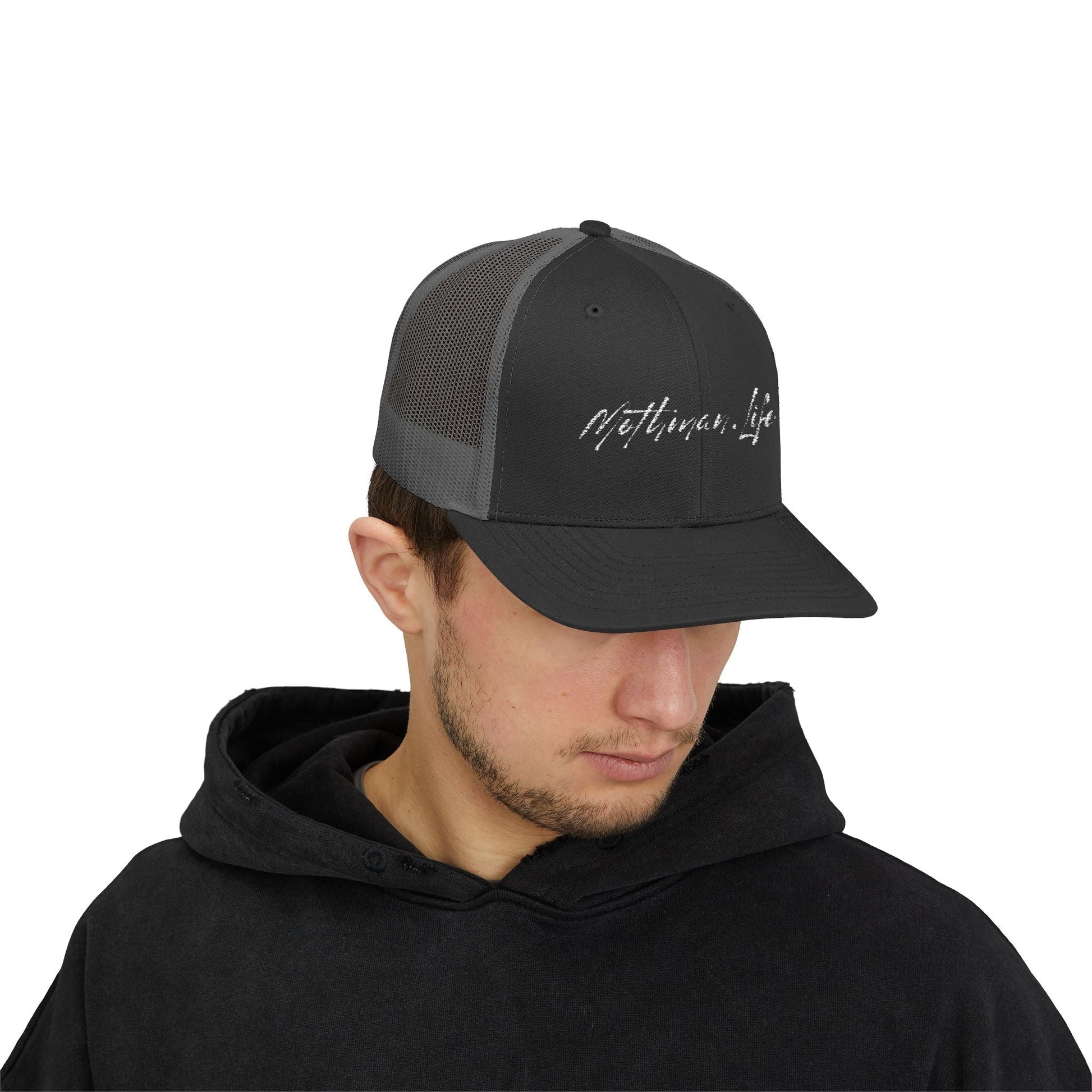 Man wearing a black and gray trucker hat with a black hoodie.