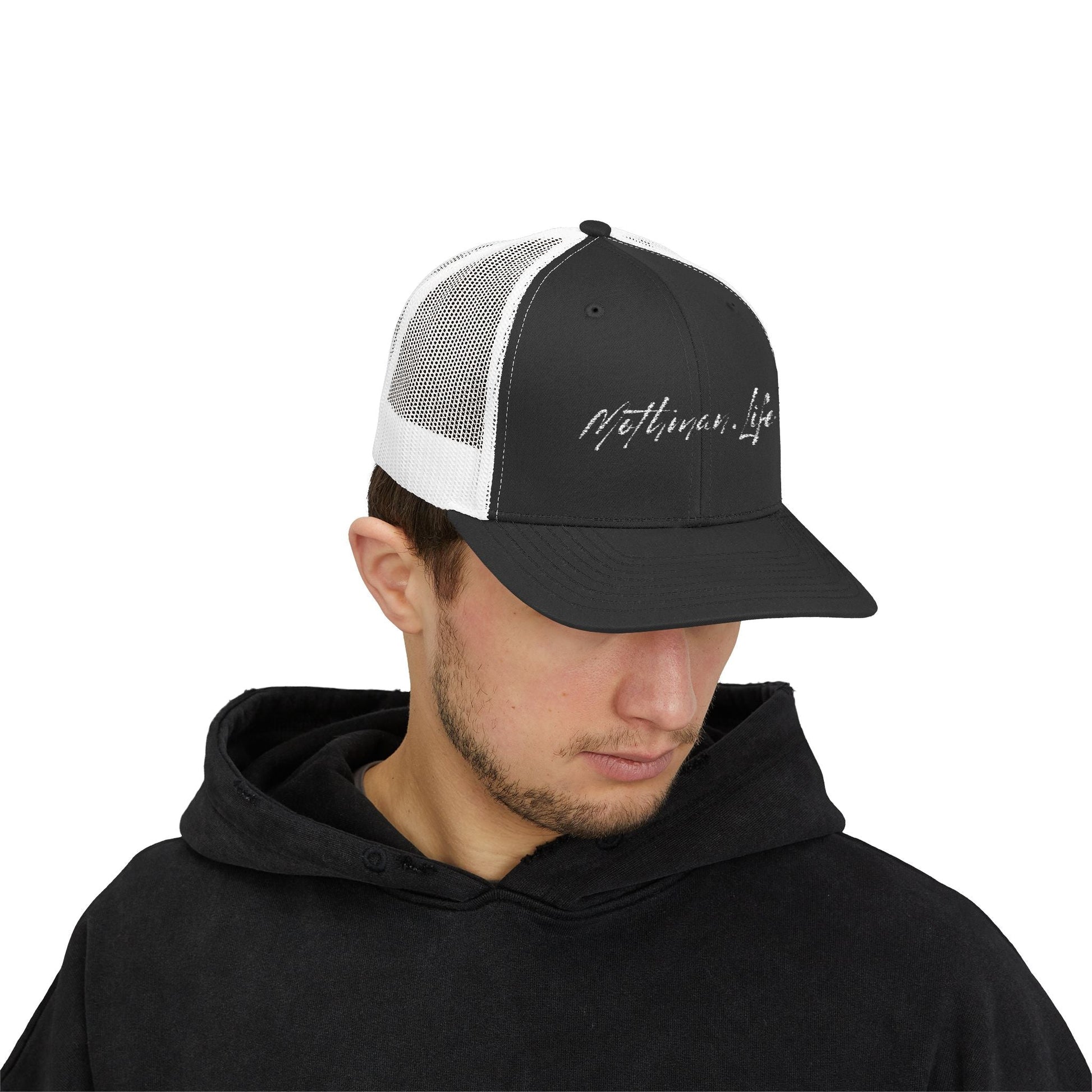 Man wearing a black and white "Mothman Life" trucker hat and black hoodie.
